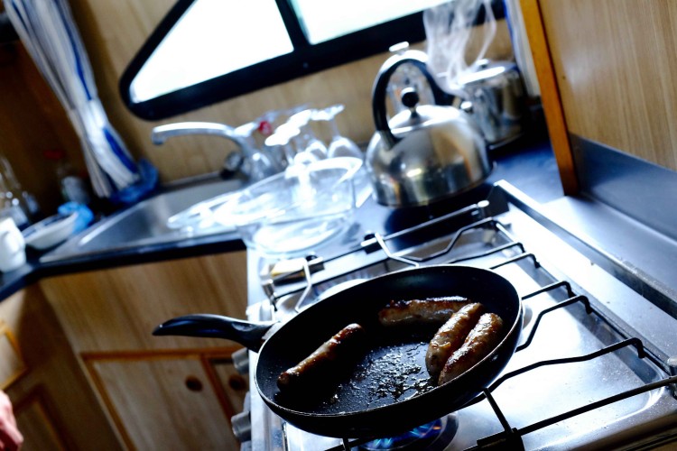 Sausages in pan on boat